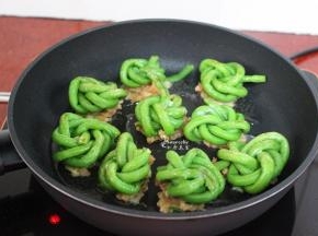 翻转另外一面继续煎，让肉煎至微黄，熟透即可出锅。豆角汆烫过，容易熟，酿肉的一面需要多煎一会。