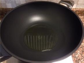 热锅倒油烧至八成热。