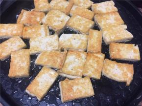 豆腐用电饼铛或者平底锅煎至两面金黄，夹出备用。