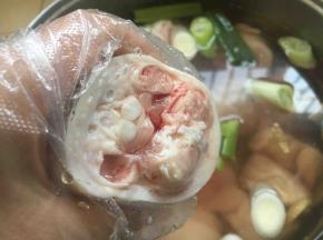 猪手浸泡后，戴上一次性手套，用双手紧紧握住猪手，使劲往外挤血水，然后再把猪手清洗干净。这步是去腥的办法之二。