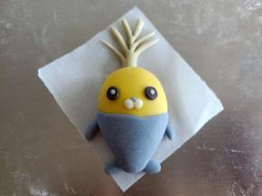 2克绿色的面团做出小萝卜的叶子来，然后把小萝卜的鼻子，眼睛做好粘上