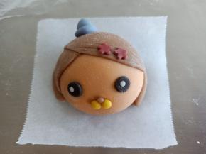 粘到突突兔的头部两边作为头发，1.5克蓝色面团做一顶帽子，眼睛鼻子做好粘上