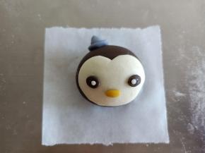 白色面团擀薄片，剪成如图形状粘到面部，再把眼睛嘴巴粘上