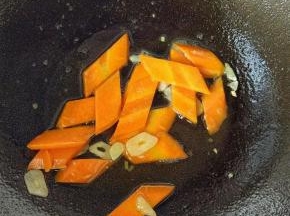锅里再放点油，放蒜片炒出味道，然后放胡萝卜片，翻炒会。