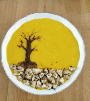 然后用牙签沾点可可糊，在芒果奶昔上面画出树干和树枝。核桃去外皮切成小块，铺在树根下方。