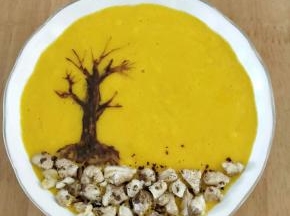 然后用牙签沾点可可糊，在芒果奶昔上面画出树干和树枝。核桃去外皮切成小块，铺在树根下方。