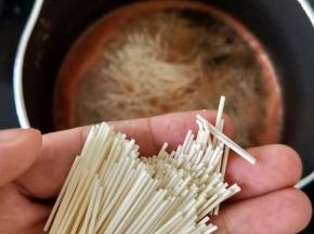 把西红柿汁倒入奶锅，再加适量水烧开。然后拿出面条，掰成小段，放入奶锅里，转小火煮。