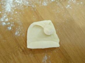 三:取一块面团搓圆，沾到帽子上。