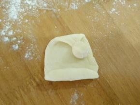 三:取一块面团搓圆，沾到帽子上。
