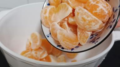 找一个大的容器，加入橘子，适量的清水。