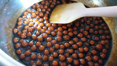 再熬糖浆，其实就是50克黑糖加120克水煮开后，再把煮熟的珍珠放进去煮，一直到糖浆浓稠，把珍珠捞起来，这时候珍珠颜色也变深了。珍珠捞出来之后余下的备用。