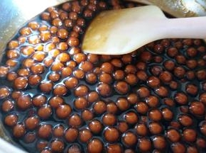 再熬糖浆，其实就是50克黑糖加120克水煮开后，再把煮熟的珍珠放进去煮，一直到糖浆浓稠，把珍珠捞起来，这时候珍珠颜色也变深了。珍珠捞出来之后余下的备用。