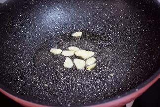 原锅倒入适量的食用油烧热，放入蒜片爆香