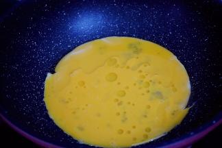 锅中倒入适量的食用油烧热，倒入打散的鸡蛋液