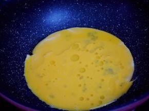 锅中倒入适量的食用油烧热，倒入打散的鸡蛋液