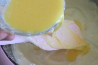 黄油牛奶液搅匀，利用倒在刮刀表面的方法，把混合液撒到蛋糕糊上，继续翻拌均匀。