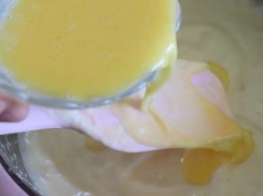 黄油牛奶液搅匀，利用倒在刮刀表面的方法，把混合液撒到蛋糕糊上，继续翻拌均匀。