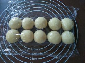 包好的蛋黄酥面团按顺序排好，全程盖膜操作，以免面团表面变干