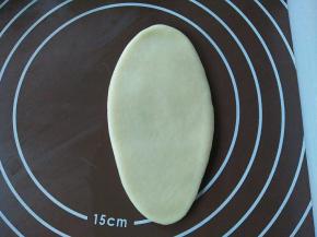 取一个面团，光滑面朝上，擀成长舌状