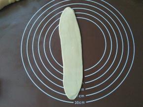 再把醒好的面团收口朝下，擀开，尽量擀长些