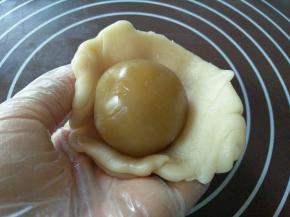 擀好的面皮包进一个莲蓉，也是用收虎口的方包包好