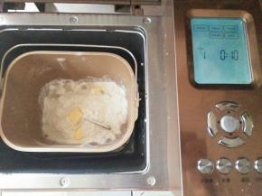 把披萨皮的材料放入面包机桶，启动揉面程序