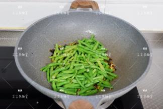 加入豆角，煸炒片刻至干燥
