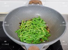 加入豆角，煸炒片刻至干燥