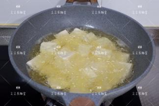 起油锅，将切好的豆腐依次下入，煎炸至双面金黄