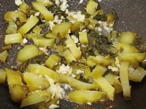 锅里加少许的油，爆香生姜蒜泥辣椒段，我加酸菜翻炒出香味。