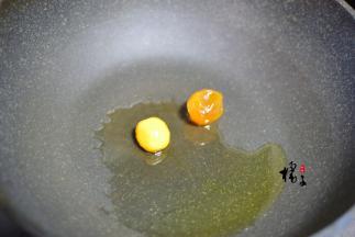 锅中加少许油，因为咸蛋黄有一些油，还因为玉米粒和豌豆都不吸油，所以不需要放太多油，加入咸蛋黄