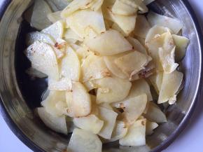 起锅热油，放入土豆片煎至边上焦黄后捞出