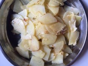 起锅热油，放入土豆片煎至边上焦黄后捞出