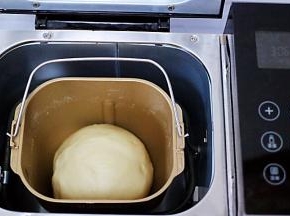 面团整成圆形，放入面包机内，盖上盖子，进行第一次发酵。