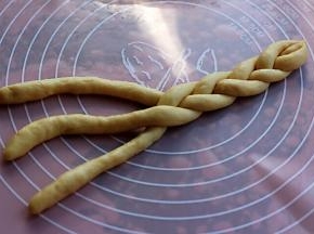 把搓好的面团开始编成三股辫子。