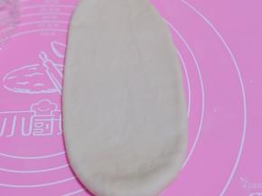 取一块面团，用擀面杖擀开，将气泡拍破。