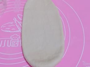 取一块面团，用擀面杖擀开，将气泡拍破。