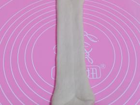 将擀好的长舌状两边向中间对折，用擀面杖轻轻擀长，由上而下卷起。