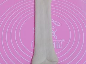 将擀好的长舌状两边向中间对折，用擀面杖轻轻擀长，由上而下卷起。