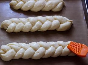 用刷子均匀地朝面包胚上刷上蛋黄液。