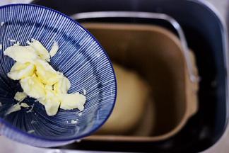 一个程序和面以后，把室温软化的黄油加入面团中，进行一个和面程序。