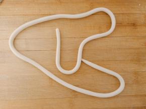 取一个面团搓成长条，长度和粗细程度根据你想做的大小和圈数决定