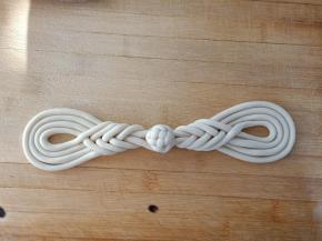 做好的琵琶扣，两个对着放，中间再用剩下的面团做一个小绣球