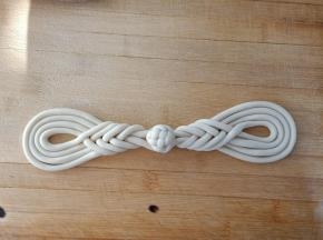 做好的琵琶扣，两个对着放，中间再用剩下的面团做一个小绣球