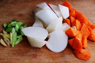 白萝卜和胡萝卜洗净后用刀切成滚刀块，葱姜切碎备用。