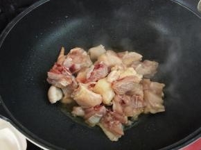 锅凉热油，下鸡块炒至微黄，加入生姜，烹入料酒