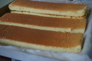 烘烤结束，将蛋糕取出，晾3分钟倒扣在另一张干净的油纸上，趁热撕掉底部的油纸，待蛋糕放凉后，切掉四条边，再切成4等份