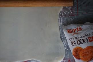 冷藏松驰过的冰皮取出，放在两张保鲜膜中间，擀成长方形（为防止粘，在里面撒一些熟糕粉）