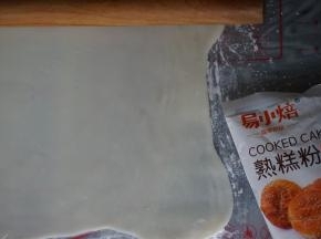 冷藏松驰过的冰皮取出，放在两张保鲜膜中间，擀成长方形（为防止粘，在里面撒一些熟糕粉）