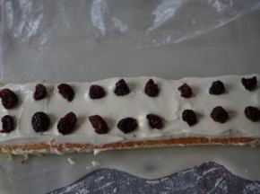 淡奶油加糖粉，隔冰水打发，用抹刀将打发好的淡奶油抹在蛋糕片上面，摆上蔓越莓干